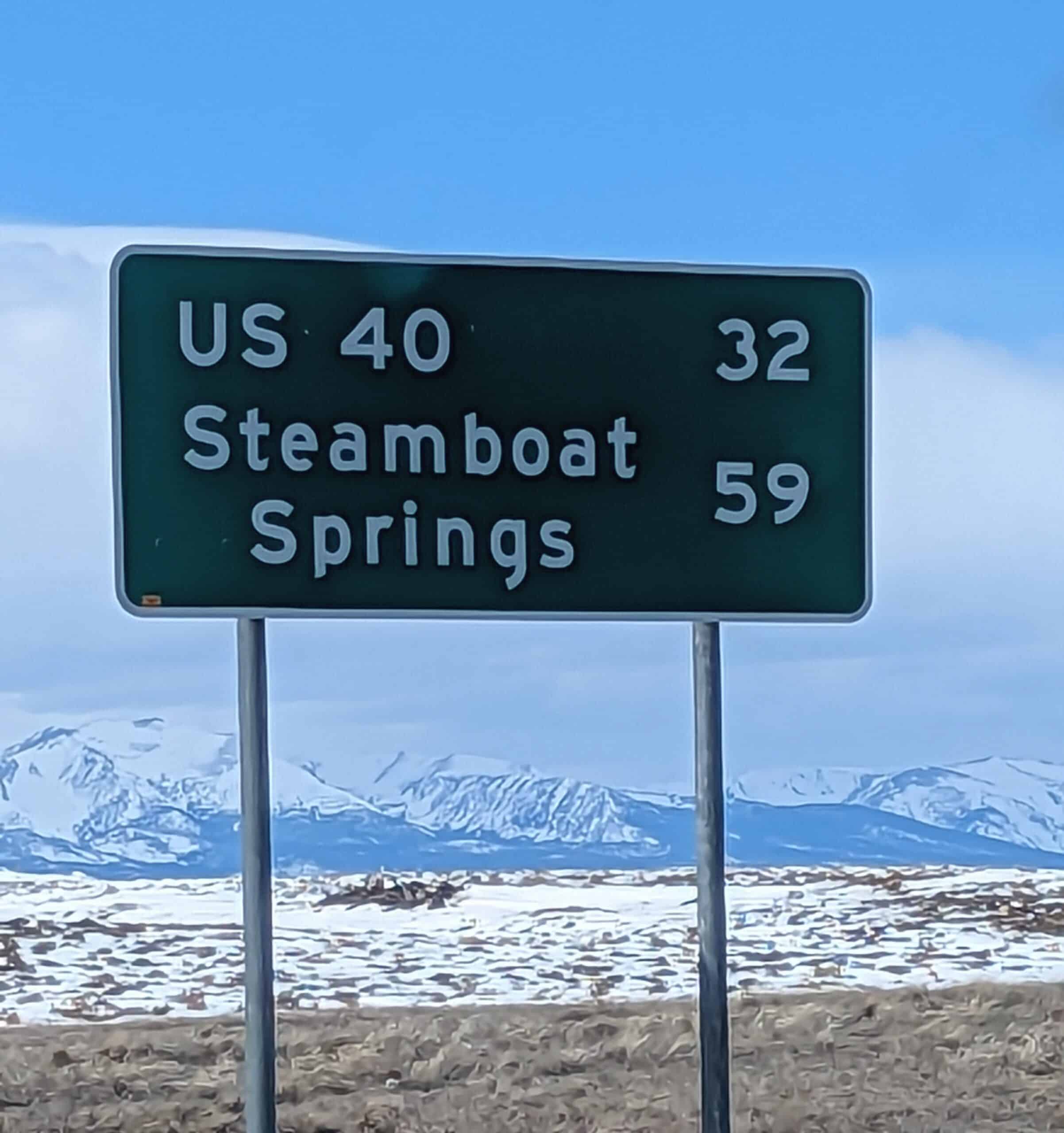 A photo of a sign showing how many miles to go to get to Steamboat Springs.