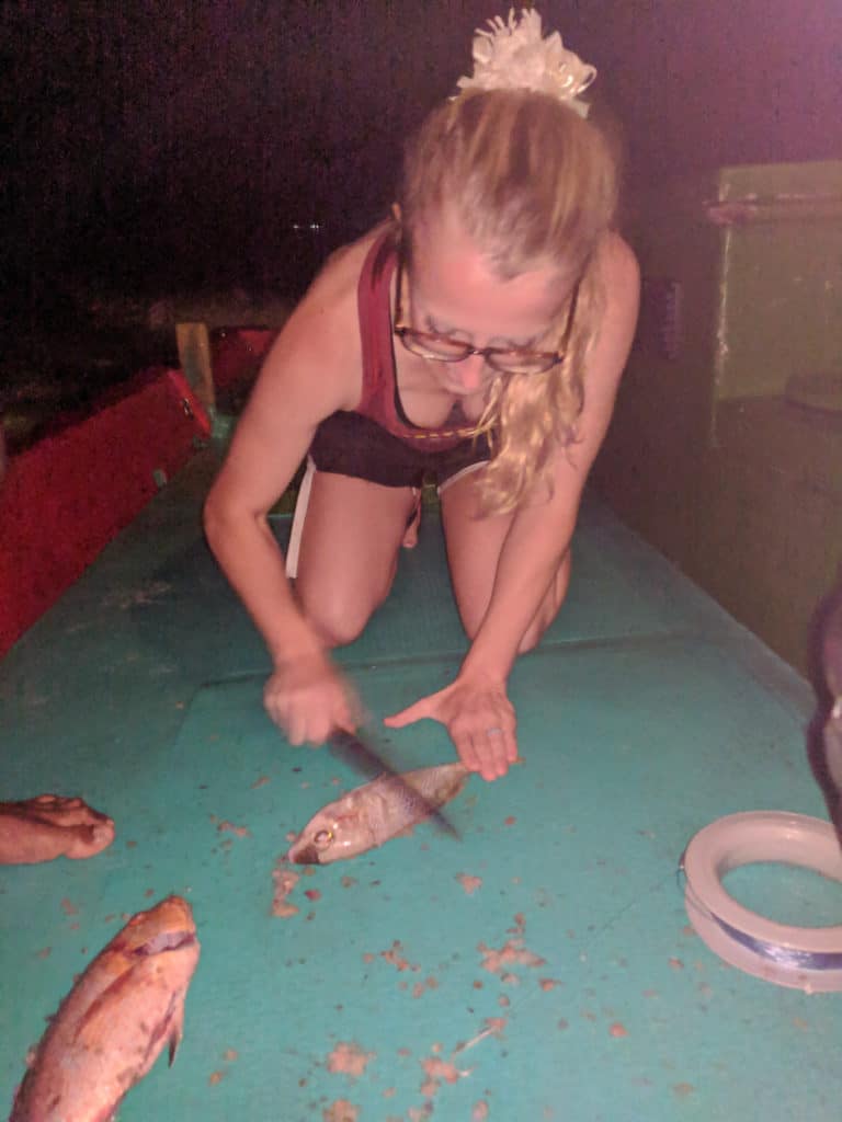Laura cleaning fish while night fishing from Maafushi island in the Maldives
